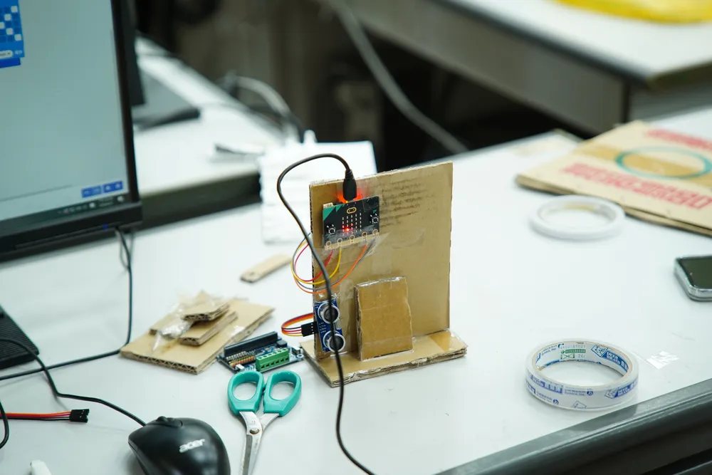 桌上的紙箱智慧家園,接上了 Microbit 電路板與感測器