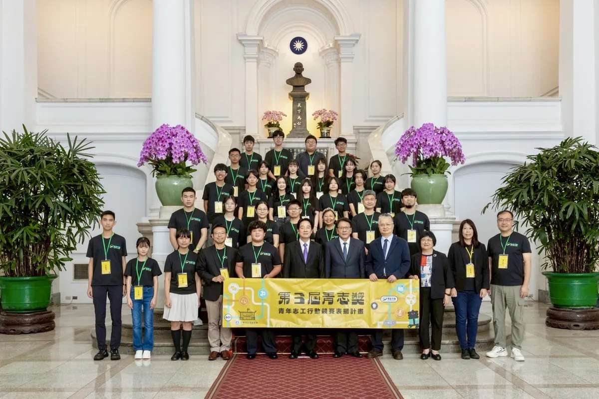 展心團隊與總統、貴賓在總統府大廳階梯前，拿著第三屆青志獎布條大合照
