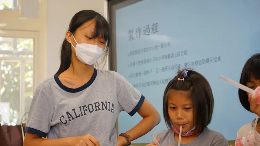 志工陪孩子用吸管做實驗